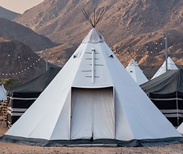 Teepees pitched below a rocky ridge
