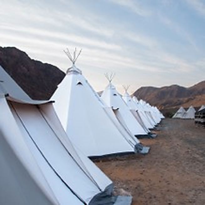 Bedding and cushions laid out inside a teepee