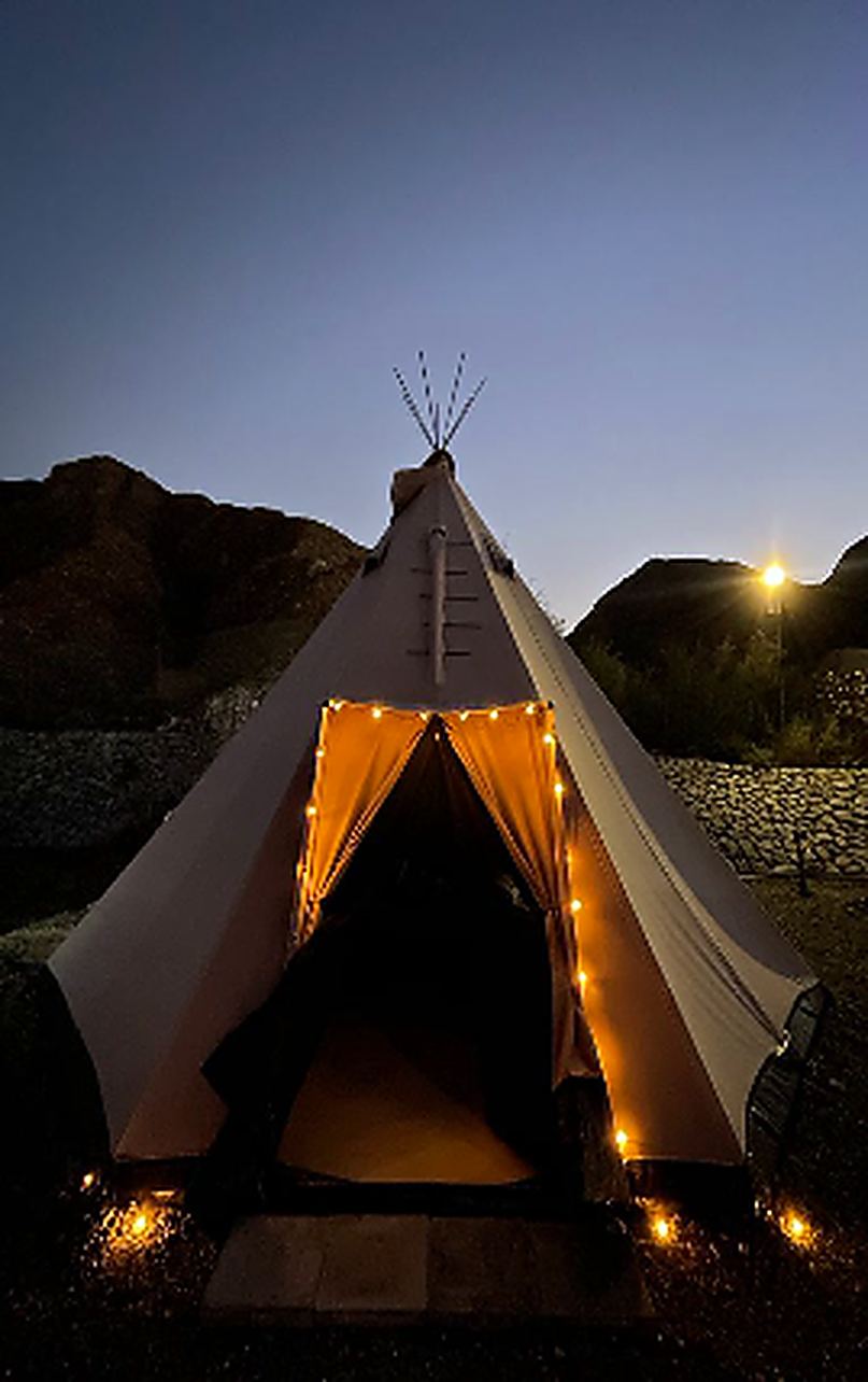A teepee glowing from within at night